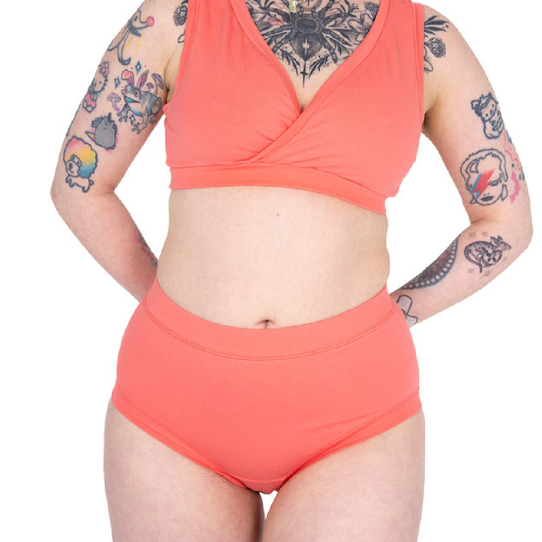 Crop of Faeryn wearing a coral bra and high rise briefs