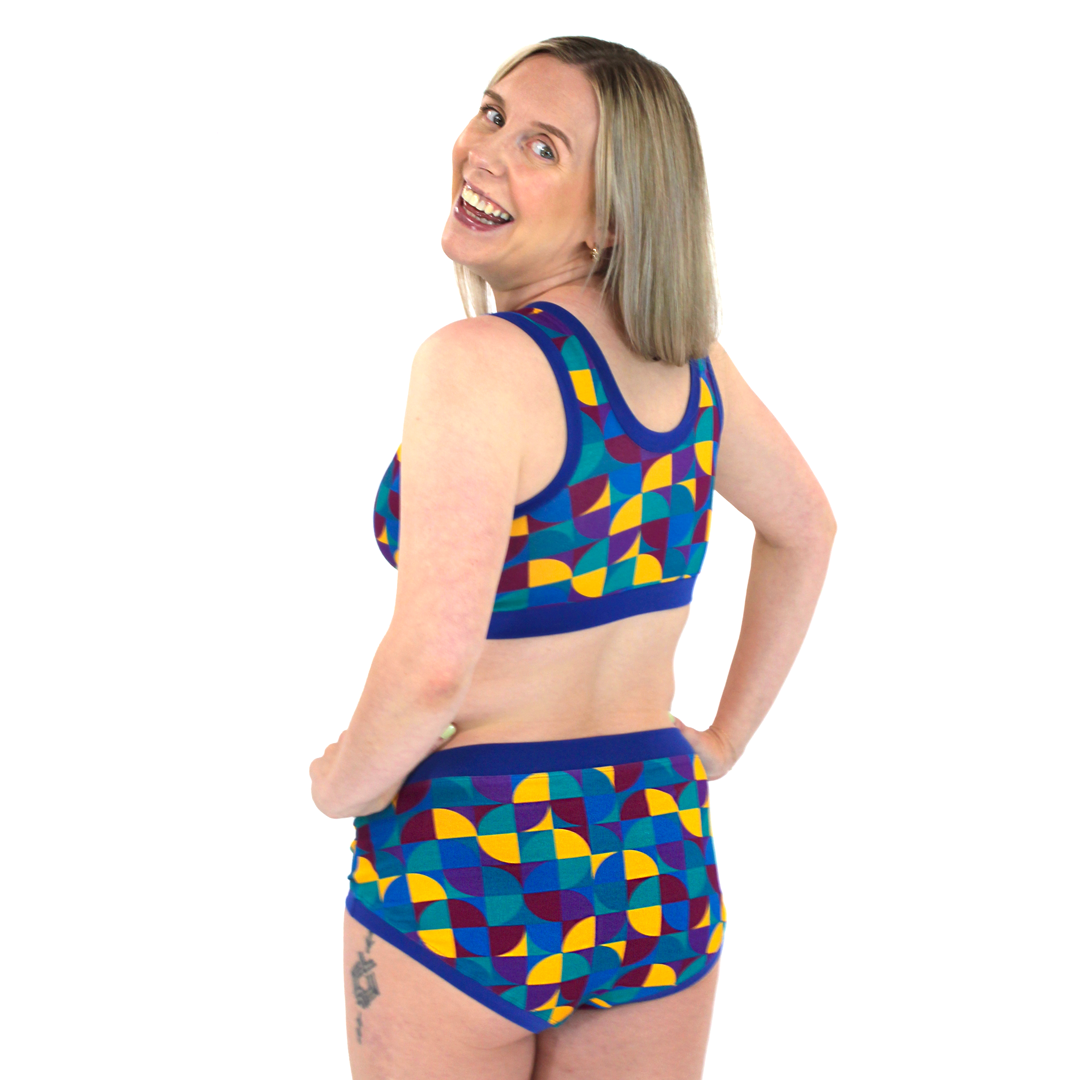 The back view of Lindsey in the Original bra and briefs in a geometric design with blue banding.