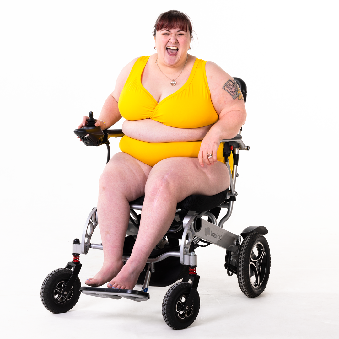 Rhona is in a marigold yellow underwear set in her electric wheelchair