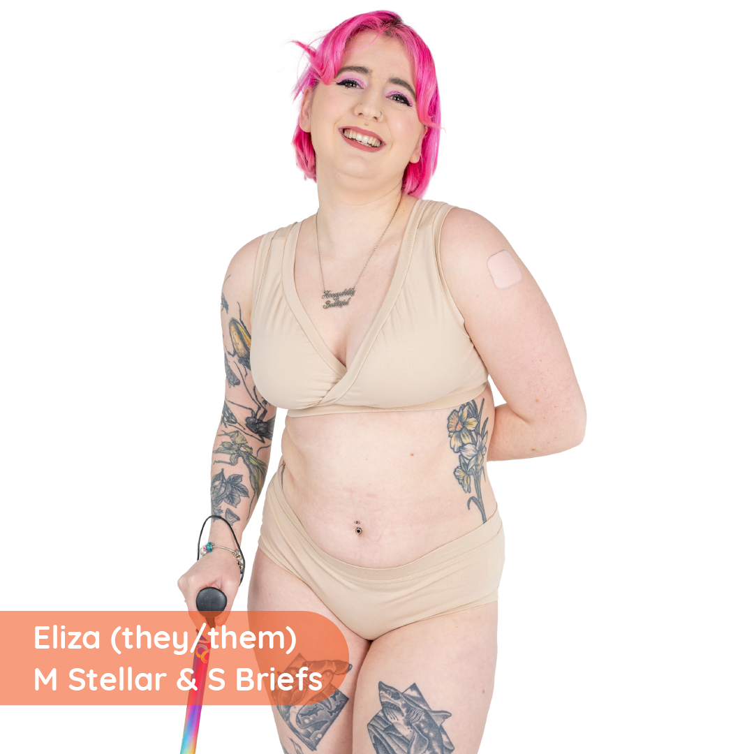 Eliza is standing wearing a nude underwear set