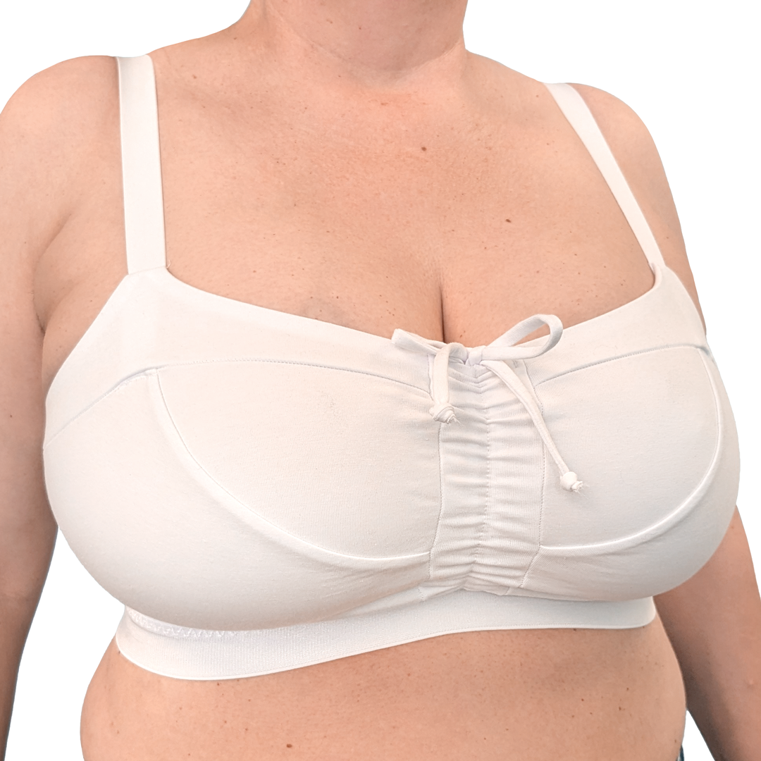 A close-up of a woman wearing a white underwire bra with a gathered center front and a small front tie detail, shown against a plain white background.