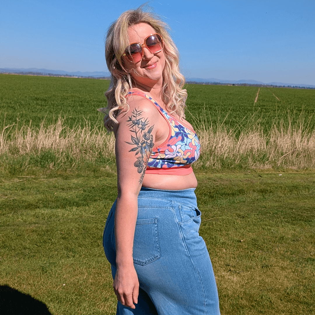 Ros is outside in the sunshine wearing a Wavy Flowers bralette and jeans