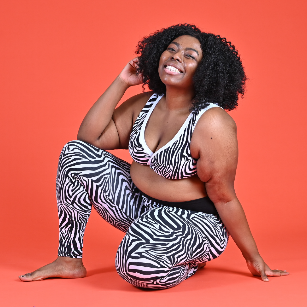 Michelle is sitting down wearing a zebra print bra and leggings