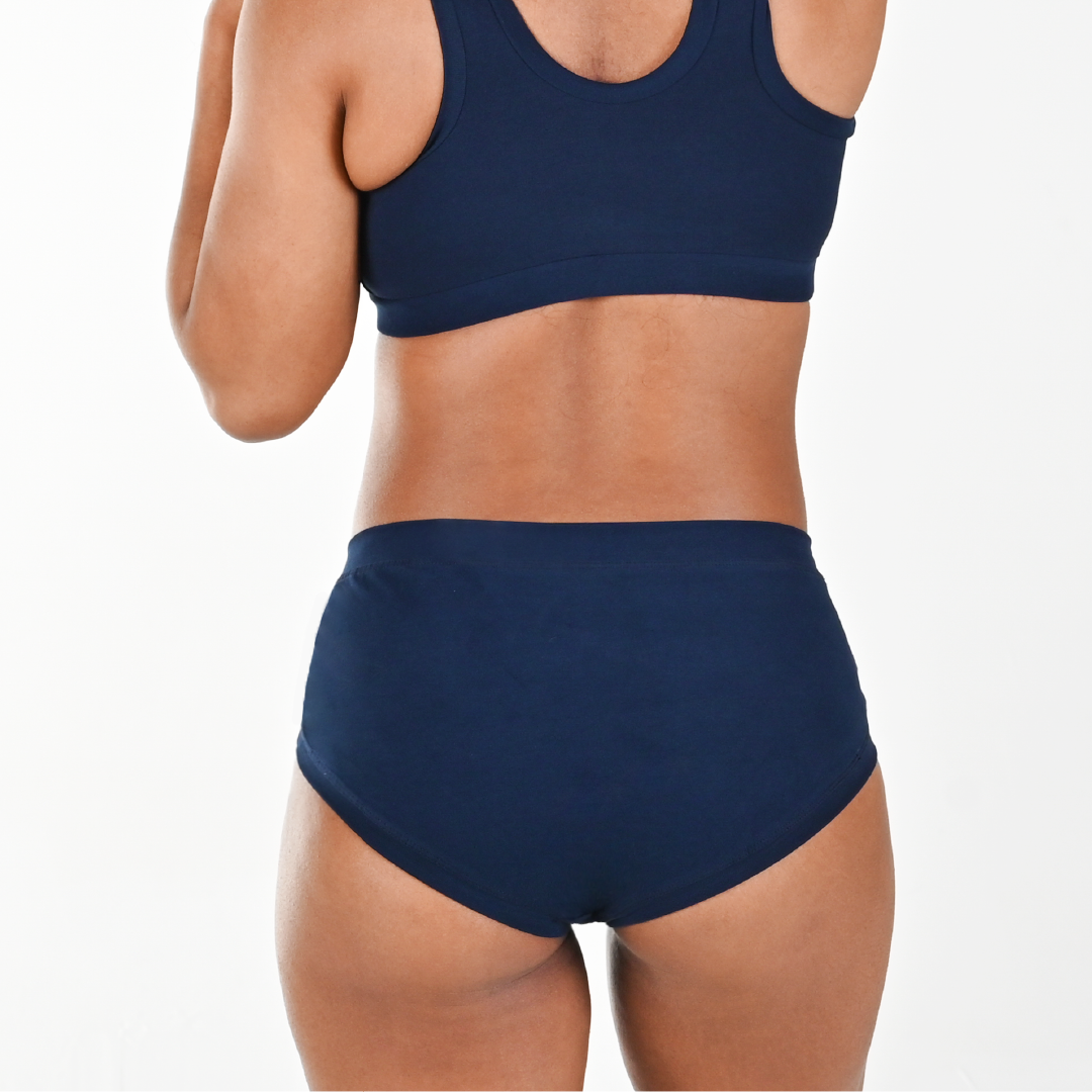 Cropped image of Precious wearing high rise navy briefs and bra